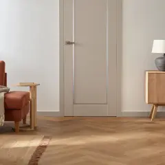 Jasne, nowoczesne drzwi wewnętrzne w neutralnym kolorze, idealnie komponujące się z przytulnym salonem.