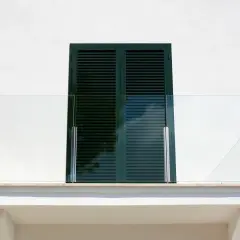 Nowoczesna obróbka balkonu z przeszkloną balustradą i okapnikiem.