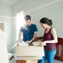 Para rozpakowuje kartony w pustym pokoju.