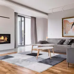 Nowoczesny salon z kominkiem i obrazem. Jasne, modne kolory ścian tworzą przytulną atmosferę.