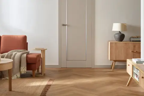 Jasne, nowoczesne drzwi wewnętrzne w neutralnym kolorze, idealnie komponujące się z przytulnym salonem.