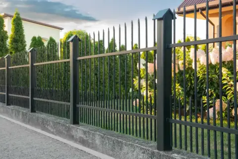 Solidny betonowy murek jako alternatywa dla podmurówki pod ogrodzenie. Elegancka czarna siatka z ostrymi zakończeniami.