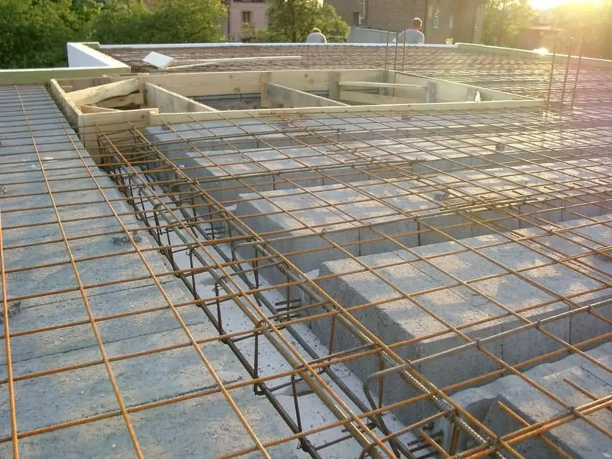 Strop gęstożebrowy w budowie, z widoczną siatką zbrojeniową i pustakami ceramicznymi.