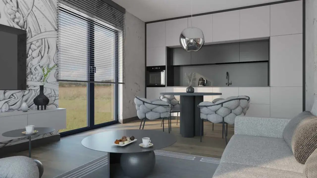 Nowoczesny salon z aneksem kuchennym: szara sofa, okrągły stolik kawowy, designerskie krzesła i stół jadalniany. Inspiracja, jak urządzić mały salon z aneksem.