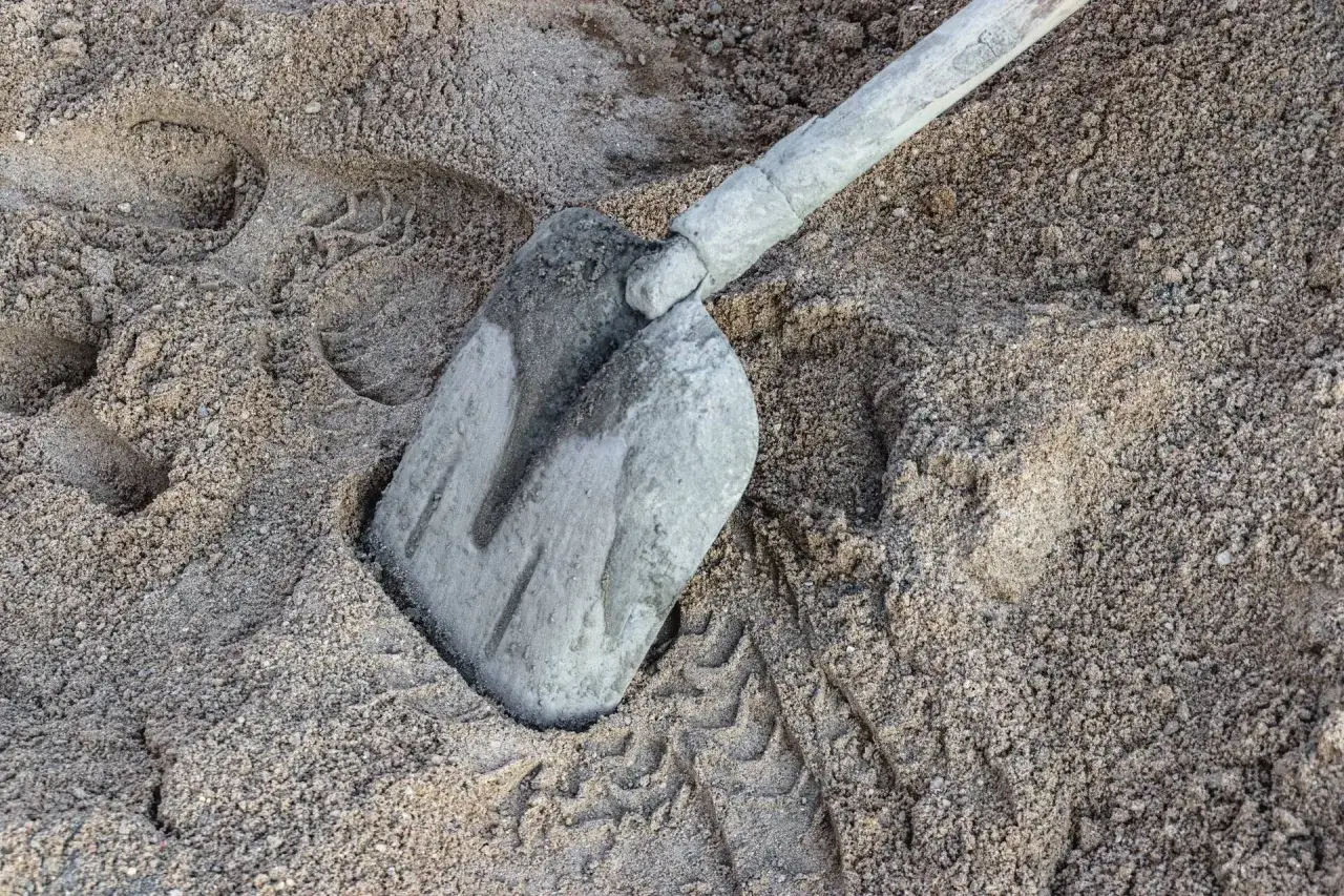 Łopata w piasku, ślady opon. Zastanawiasz się, ile cementu na kubik betonu?